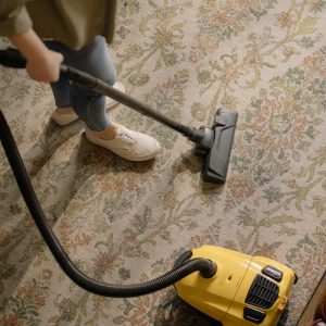 Person Using a Yellow and Black Vacuum Cleaner